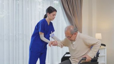 Asyalı genç kadın hemşire desteği engelli yaşlı adam tekerlekli sandalyede 
