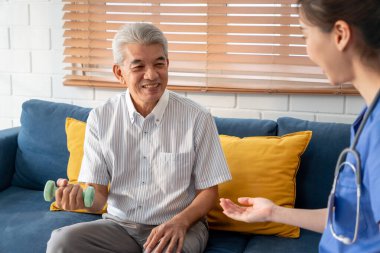 Asyalı yaşlı bir adam hemşirenin desteğiyle fizyoterapiste gidiyor. Olgun yaşlı erkek hasta oturma odasında kanepede oturup evde bakım yapan hastayla dambıl egzersizi yapıyor..