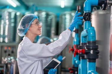 Kafkas kadın bilim adamı fabrika deposunda laboratuarda çalışıyor. Çekici kadın kimyager, bilimsel araştırma laboratuarında maden suyu şişelerini incelerken kimyasal bir numuneyi analiz etti..