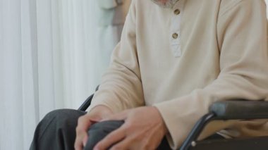 Asyalı yaşlı bir adam acı çekiyor ve bacağı yaralı..