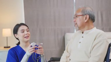 Tıp bürosunda yaşlı bir adamla konuşan bir kadın.