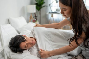 Asyalı genç bir eş hasta kocasının üzerine battaniye örttü ve yatakta uyudu. Çekici, güzel bir kadın. Kendine iyi bak ve uyuyan erkek arkadaşına destek ol. Yatak odasında uzan..