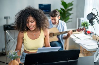 Çeşitli arkadaşlar gitar çalıyor ve evde elektronik film müzikleri yapıyor. Müzik stüdyosunda müzik aleti ve ses ekipmanı kullanarak yeni bir şarkı besteleyen çekici erkek ve kadın müzisyen.