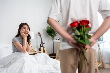 Asyalı genç adam sürpriz yaptı ve gül çiçeğini güzel kız arkadaşına verdi. Çekici, romantik, yeni evli çift erkek ve kadın yıl dönümünü ve Sevgililer Günü 'nü kutlamak için birlikte evde vakit geçirirler..