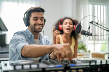 Müzik stüdyosunda çalışan çeşitli genç ve şık ses yapımcıları. Çekici sanatçı müzisyen besteci erkek ve kadın şarkılarda ustalaşıyor ve müzik stüdyosunda yeni bir şarkı yaratmak için karıştırma tahtası kullanıyor..