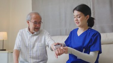 Hemşire içeride yaşlı bir adamın kan basıncını ölçüyor.