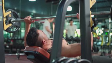 Genç atletik bir adam, profesyonel bir spor salonunda sabah seansında fiziksel durumunun zirvede olduğunu gösteriyor..