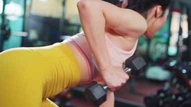 Modern spor salonunda spor giyim eğitimi alan atletik genç bir kadın.