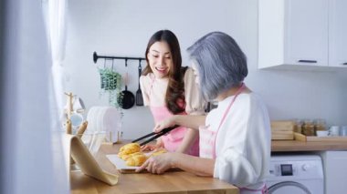 Modern mutfak ortamında yemek hazırlayan iki kadın.