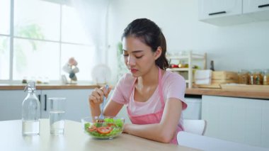 Masada oturan kadın salata yiyor.