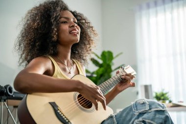 Afrikalı kadın gitar çalıyor ve evde elektronik film müzikleri yapıyor. Çekici bayan piyanist besteci, müzik stüdyosunda midi piyano ve ses ekipmanları üzerine yeni bir şarkı yaratıyor..