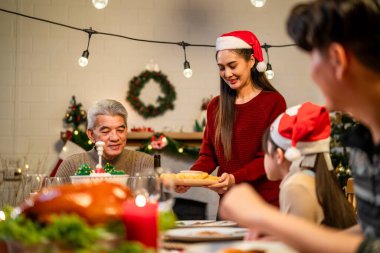 Asyalı sevimli aile Noel partisini evde kutluyor. Çekici ebeveynler ve akrabalar Şükran Günü 'nü kutlamak için yemek yiyorlar. Noel arifesi evde yemek masasında..
