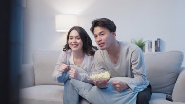 Evde birlikte film izleyen bir çift.