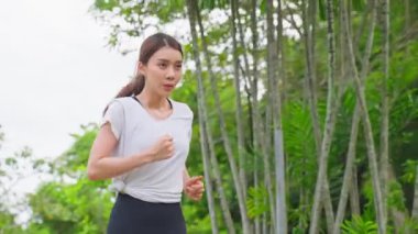 Orman yolunda koşan genç bir kadın.