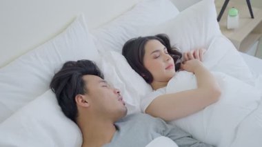 Genç çift yatakta yan yana uyuyor..