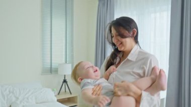 Bebek tutan ve gülümseyen bir kadın..