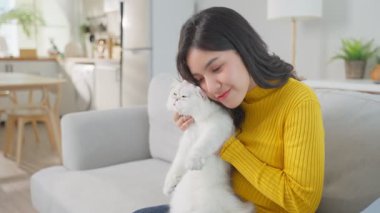 Kucağında kedi tutan genç bir kadın..