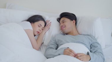 Yatakta birbirine gülümseyen bir çift.