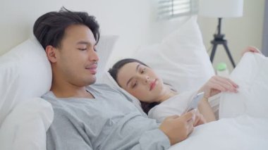 Çift telefonda yatakta dinleniyor.