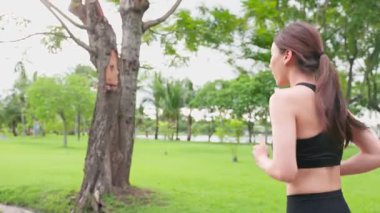 Kadın Asyalı koşucu yaz parkında koşuyor.