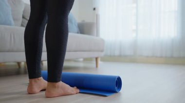 Mavi yoga minderinin üzerinde duran kişi içeride.