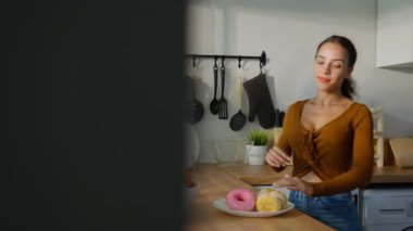 Kahvaltıda meyveli çörek yiyen bir kadın.