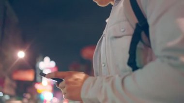 Gece vakti akıllı telefon kullanan genç adam.