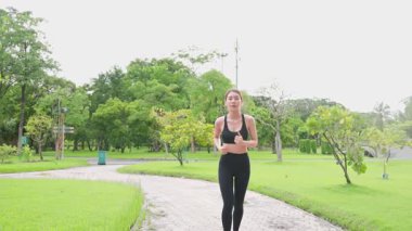 Kadın Asyalı koşucu yaz parkında koşuyor.
