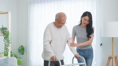 İçeride yürüyen yaşlı bir adama yardım eden kadın..