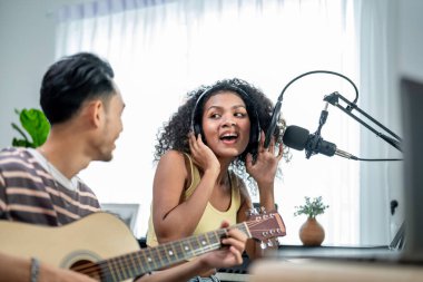 Çeşitli arkadaşlar gitar çalıyor ve evde elektronik film müzikleri yapıyor. Müzik stüdyosunda müzik aleti ve ses ekipmanı kullanarak yeni bir şarkı besteleyen çekici erkek ve kadın müzisyen.