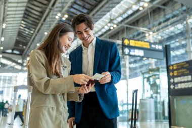 Havaalanı terminalinde tablet kullanan genç işadamı Asyalı bir kadın..