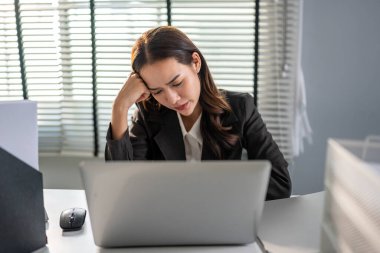 Hüsrana uğramış Asyalı genç iş kadını iş yerinde geç saatlere kadar çalışıyor. Masada oturan çekici bayan çalışan, şirketteki dizüstü bilgisayarda çalışırken stresli ve hayal kırıklığına uğramış hissediyor..