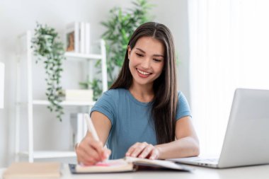 Mutlu öğrenci kız evde online çalışıyor.