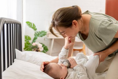 Anne yatak odasında süt ile bebeği besliyor.