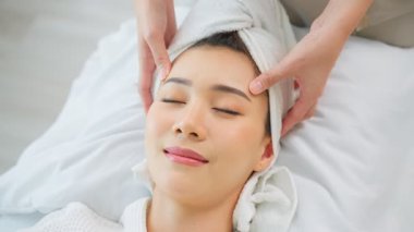 Kadın yüz masajı yaptırıyor.
