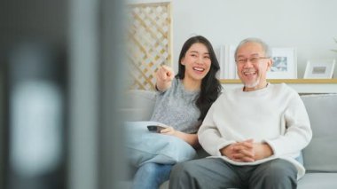 Gülümseyen kadın ve yaşlı adam birlikte oturuyor.