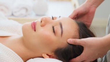 Mutlu Asyalı kadın kuaförde masaj yaptırıyor, sağlık ve güzellik konsepti.