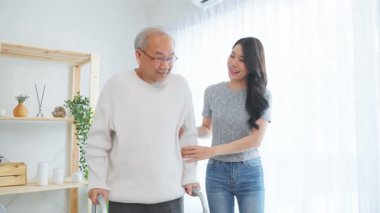 Genç kadın içeride yaşlı adama yardım ediyor.