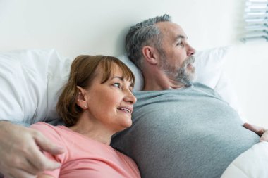 Kafkasyalı yaşlı çift, evde uyandıktan sonra yatağa uzanıyorlar. Çekici, yaşlı, pijamalı kadın ve erkek evdeki yatak odasında sabahın erken saatlerinde eğleniyorlar. Aile ilişkisi kavramı.