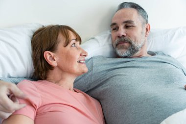 Kafkasyalı yaşlı çift yatağa uzanıp birbirlerine bakıyorlar. Çekici, yaşlı, pijamalı kadın ve erkek evdeki yatak odasında sabahın erken saatlerinde eğleniyorlar. Aile ilişkisi kavramı