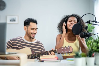Çeşitli arkadaşlar gitar çalıyor ve evde elektronik film müzikleri yapıyor. Müzik stüdyosunda müzik aleti ve ses ekipmanı kullanarak yeni bir şarkı besteleyen çekici erkek ve kadın müzisyen.