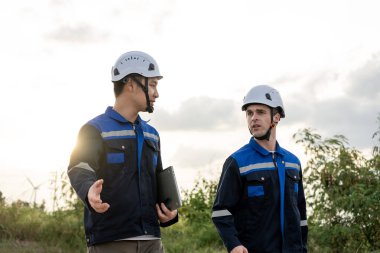 Açık hava deposunda çalışan çeşitli erkek teknisyenler. Yenilik mühendisi güvenlik donanımı giyen adamlar depo fabrikasının dışında çevresel yenilenebilir temiz enerji geliştirmek için çalışıyorlar..