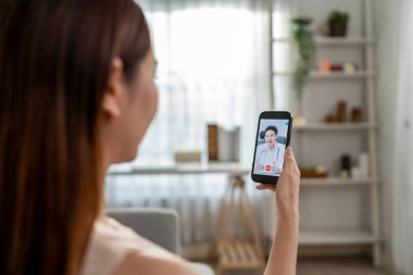 Asyalı genç bayan hasta internette doktorla konuşuyor. Çekici bir doktor, tele sağlık teletıp videosu çekiyor. Evdeki hasta kıza internet danışmanlığı tanısı konuyor..