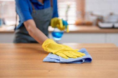 Evdeki temizlikçi kadın mutfağını temizlerken ellerini kapat. Güzel genç kız temizlikçi mutlu ve temizlik için kirli yemek tezgahını temizliyor.