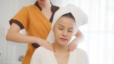 Bir kadın pratisyenin masaj masasında uzanan bir kadın için canlandırıcı bir tedavi uyguladığı huzurlu spa sahnesi..