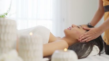 Genç Asyalı kadın kafa masajı alıyor. Rahatlatıcı spa tedavisi görüyor.
