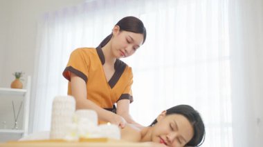 Kadın terapist, barışçıl bir aromaterapi seansı sırasında kadın müşteriye tedavi uyguluyor.