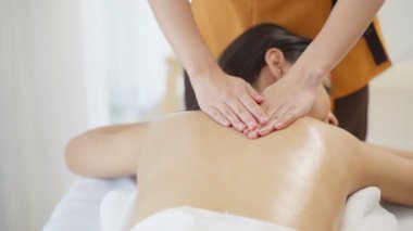 Profesyonel kadın masaj terapisti lüks kaplıcalardaki gevşemiş kadın müşteriye sağlıklı yaşam tedavisi uyguluyor. .