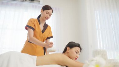 Kadın terapist, barışçıl bir aromaterapi seansı sırasında kadın müşteriye tedavi uyguluyor.