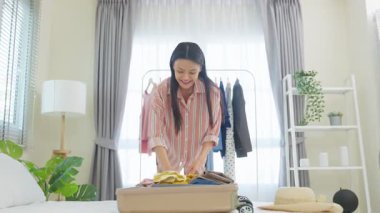 Giysileri bavula koyan genç kadın.